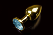 Маленькая золотистая анальная пробка с круглым кончиком и голубым кристаллом - 7 см. - 0